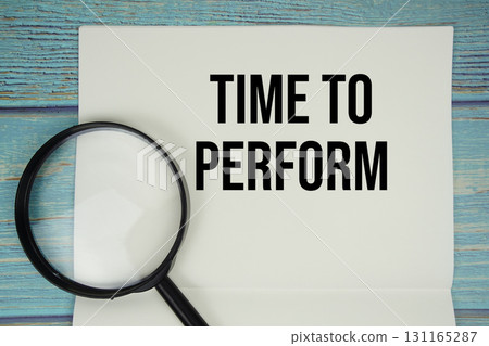 Time To Perform text written on notepad with magnifying glass flat lay on wooden background Time To Perform text written on notepad with magnifying glass flat lay on wooden background 131165287