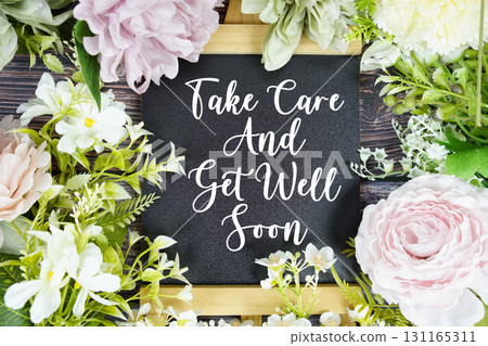 Take care and get well soon text with flowers bouquet decoration on wooden background 131165311