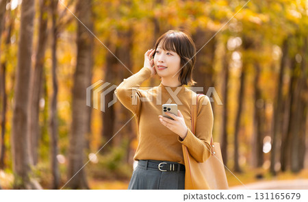 Autumn leaves of roadside trees and women/businesswomen Autumn leaves of roadside trees and women/businesswomen 131165679
