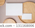 Empty white blank greeting or invitation card, name card, wooden plate on beige background. Mock up presentation. 131168006