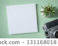 Empty white blank greeting or invitation card, vintage camera, cactus on green background. 131168018