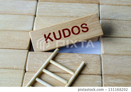 Kudos text written on a single wooden block with wooden ladder representing celebrating achievements and recognition. Kudos text written on a single wooden block with wooden ladder representing celebrating achievements and recognition. 131168202