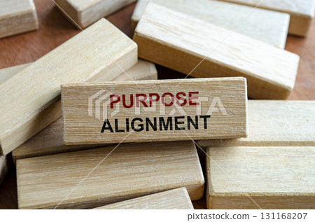 Purpose alignment text written on wooden blocks symbolizing synchronization of goals and mission. 131168207