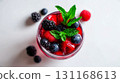Top view of berry mocktail with blackberries, blueberries, raspberries, mint leaves and crushed ice on plain white background, cocktail shines in vibrant red tones, refreshing summer drink concept 131168613