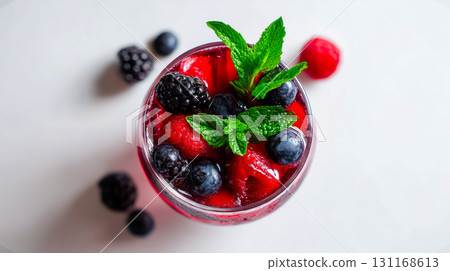 Top view of berry mocktail with blackberries, blueberries, raspberries, mint leaves and crushed ice on plain white background, cocktail shines in vibrant red tones, refreshing summer drink concept Top view of berry mocktail with blackberries, blueberries, raspberries, mint leaves and crushed ice on plain white background, cocktail shines in vibrant red tones, refreshing summer drink concept 131168613