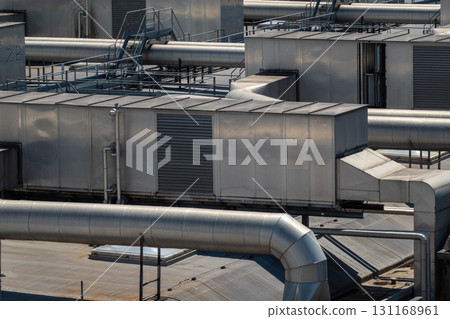Industrial rooftop ducts and metal buildings on a large factory roof 131168961