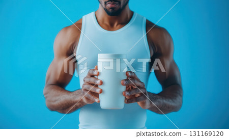 fitness enthusiast holding sports drink container, showcasing strength and determination. blue background enhances focus on subject fitness enthusiast holding sports drink container, showcasing strength and determination. blue background enhances focus on subject 131169120