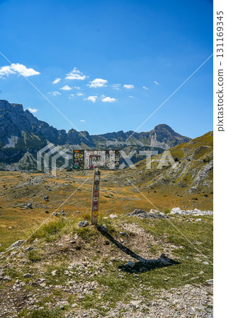 Sign of Durmitor National Park with scenic mountains and hills in the background, located in Sedlo, Montenegro. Perfect for travel, adventure, and nature content. 131169345