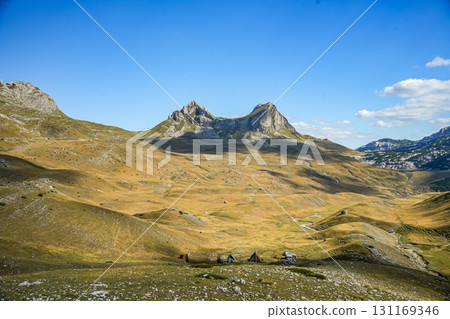 Panoramic view of saddle-shaped mountain peaks in Sedlo, Durmitor National Park, Montenegro, with scenic hills and dramatic cloudy sky. 131169346