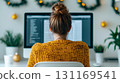 creative workspace featuring woman working on computer screen, surrounded by festive decorations and plants, creating cozy atmosphere 131169541