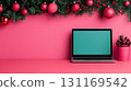 festive workspace featuring laptop, Christmas decorations, and pinecone plant. vibrant pink background adds cheerful touch to holiday season 131169542