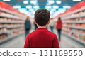 child in red sweater stands in store aisle, observing shelves filled with products. atmosphere is lively and inviting, perfect for family shopping experience 131169550