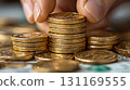 Stacking gold coins symbolizes wealth and investment opportunities. image captures hand carefully arranging coins, reflecting financial planning and prosperity 131169555