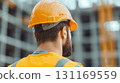 Construction worker wearing safety helmet and vest, observing site 131169559