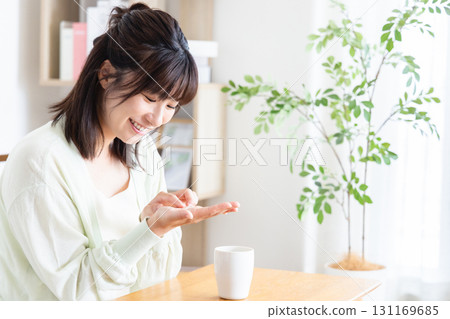 A woman drinking supplements A woman drinking supplements 131169685