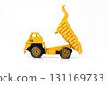 A vibrant yellow toy dump truck with its bed raised is isolated on a clean white background, creating a simple and graphic product shot. 131169733
