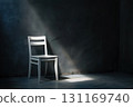 A solitary white chair is illuminated by a single ray of sunlight in an otherwise dark and empty room, creating a dramatic and minimalist scene. 131169740