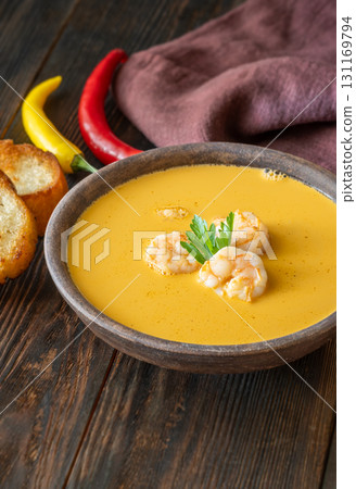 Rustic shrimp bisque with toasted baguette slices beside clay bowl Rustic shrimp bisque with toasted baguette slices beside clay bowl 131169794