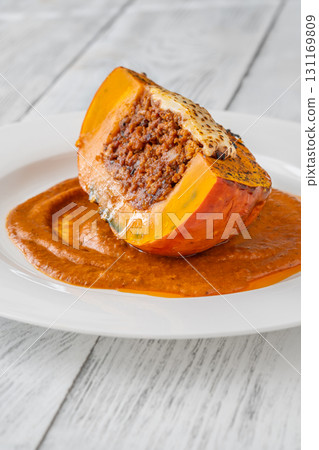 Portion of baked Hokkaido pumpkin with beef, tomato sauce, mozzarella cheese Portion of baked Hokkaido pumpkin with beef, tomato sauce, mozzarella cheese 131169809
