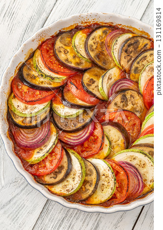 Round baking pot filled with circularly arranged baked vegetable ratatouille Round baking pot filled with circularly arranged baked vegetable ratatouille 131169814