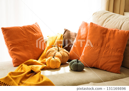 Autumnal living room decor with corduroy pumpkins and cozy pillows. 131169896