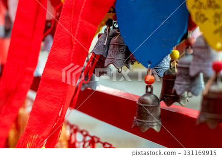 Carved bronze bells and red ribbons with Chinese characters at a temple. Carved bronze bells and red ribbons with Chinese characters at a temple. 131169915