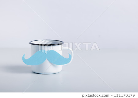 Paper blue mustache on a coffee mug on a table copy space Paper blue mustache on a coffee mug on a table copy space 131170179