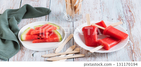 Watermelon popsicles on wooden sticks on a plate on a table web banner Watermelon popsicles on wooden sticks on a plate on a table web banner 131170194