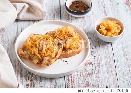 Sweet apple jam on croutons on a plate on the table Sweet apple jam on croutons on a plate on the table 131170196