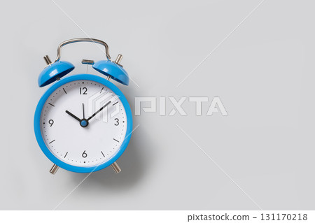 Blue alarm clock on gray background. Space for design. View from above. 131170218