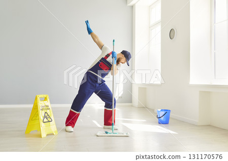 Man Cleaner Mopping Floors And Dancing Happily During Housecleaning Man Cleaner Mopping Floors And Dancing Happily During Housecleaning 131170576