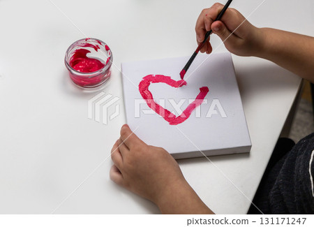 The child paints a red heart The child paints a red heart 131171247