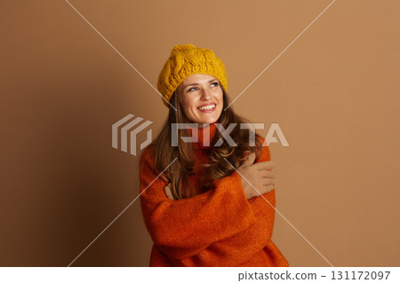 Cheerful Woman in Orange Turtleneck and Yellow Beanie 131172097