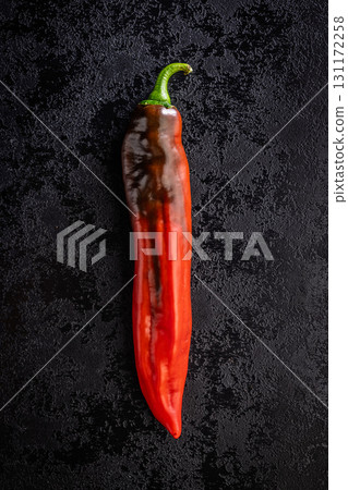 Corno di Toro Rosso pepper. Red paprika vegetable on black table. Top view. Corno di Toro Rosso pepper. Red paprika vegetable on black table. Top view. 131172258