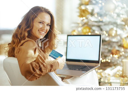 Smiling Woman Engages in Festive Online Shopping 131173735