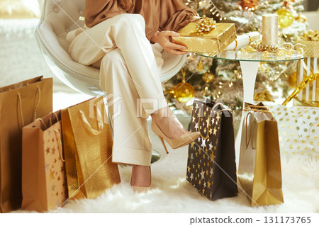 Woman Holding Elegant Gold Christmas Gift Woman Holding Elegant Gold Christmas Gift 131173765