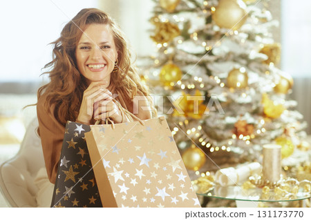 Woman Holding Two Shopping Bags by Flocked Tree Woman Holding Two Shopping Bags by Flocked Tree 131173770