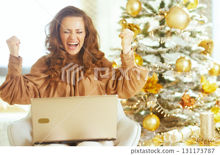 Excited Woman Celebrating Triumph with Laptop 131173787