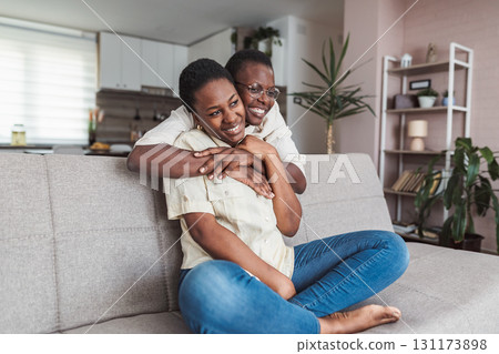 Mother and daughter hugging on the sofa, enjoying quality time together 131173898