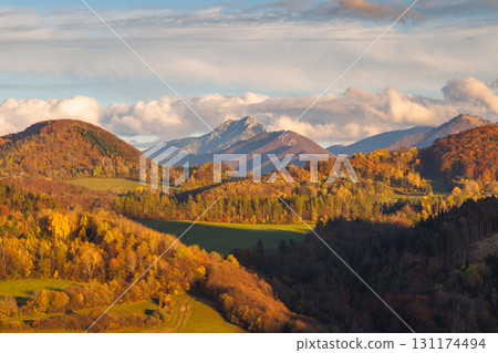 Autumnal hues paint rolling hillsides beneath a dramatic sky, showcasing nature's vibrant seasonal spectacle. The Mala Fatra national park in Slovakia, Europe. 131174494