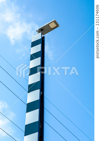 Modern LED street light with vertical black and white reflective panels against a clear blue sky 131174606