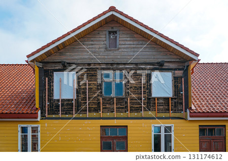 Historic wooden house renovation with new siding and insulation under reconstruction process 131174612