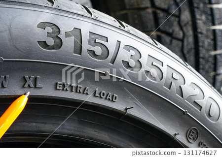 Close-up of tire sidewall with size marking 315-35R20 and XL extra load specification visible Close-up of tire sidewall with size marking 315-35R20 and XL extra load specification visible 131174627