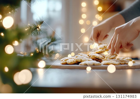 Cozy holiday baking scene with hands arranging festive cookies in warm candlelit ambiance Cozy holiday baking scene with hands arranging festive cookies in warm candlelit ambiance 131174983