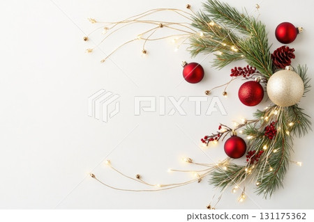 Festive christmas garland with red and gold ornaments, pinecones, and twinkling lights 131175362