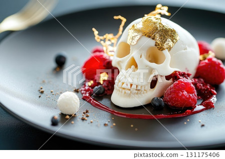 Gourmet skull dessert with raspberries and gold leaf on elegant plate 131175406