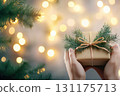 Festive gift exchange with decorative evergreen and golden glittering lights 131175713