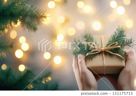 Festive gift exchange with decorative evergreen and golden glittering lights 131175713