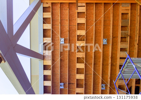 Workers are renovating an interior space, revealing wooden ceiling structure beams supports frame scaffolding for support. Workers are renovating an interior space, revealing wooden ceiling structure beams supports frame scaffolding for support. 131175938