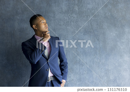 Man in suit standing against wall 131176310